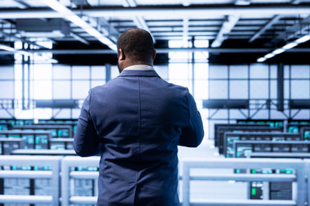 Technician in data center identifying and solving technical bugs related to data center hardware. IT specialist managing, maintaining and securing server hub workspace and supercomputers insideの写真素材