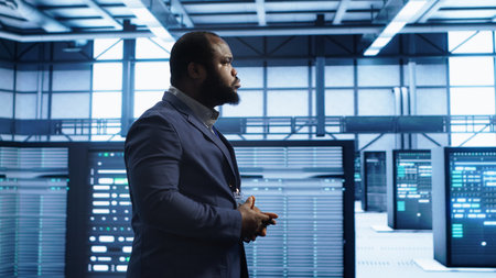 Admin inspecting server farm equipment, walking between supercomputers. IT specialist doing evaluation of data center workspace, checking equipment, monitoring performance, camera Aの写真素材