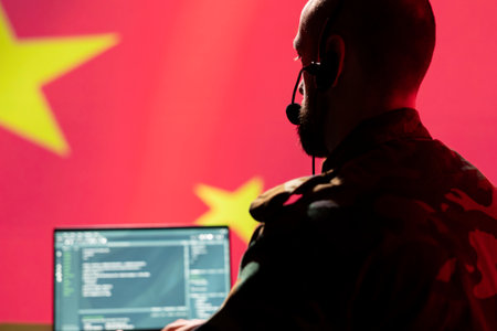 Chinese developer making bot accounts spreading misinformation online meant to criticize Western countries. Software developer working for China programming troll farm promoting communist ideologyの写真素材