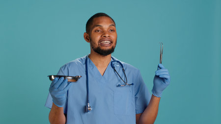 Portrait of doctor holding surgical equipment, preparing to do medical procedure, studio background. Healthcare expert gathering surgery tools needed for operation, camera Aの写真素材