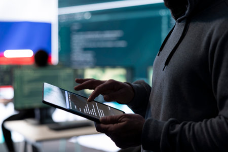 Person in an IT environment with a flag on big screen, using a tablet.の写真素材