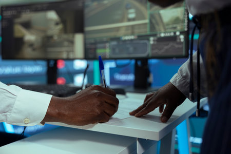 African american employee signing a new work contract to handle all orders, studying logistics and cargo shipment activity in control center at agency office. Worker works on shipping parcels.の写真素材