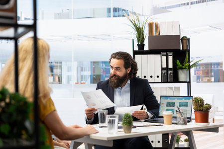 Financial advisor sitting in office with parent and child to provide personalized spending planning. Economic agent in workspace evaluating clients financial needs, helping them meet their goalsの写真素材