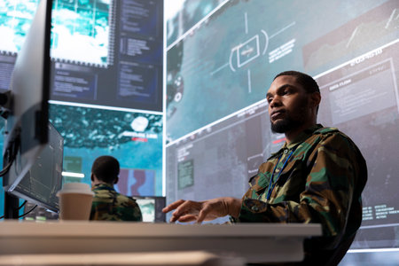 Military staff in a high tech command post examine crucial information, gathering real time surveillance footage via cctv satellite system for national security. Protocols to defensive tactics.の写真素材