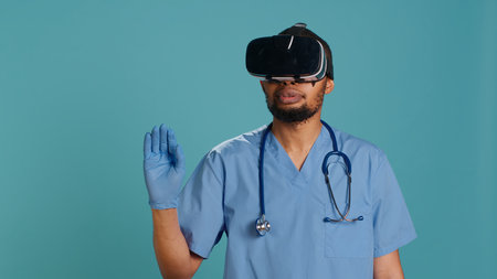 African american doctor wearing virtual reality goggles, remotely operating patient. Hospital staff member using high tech medical vr device, isolated over studio backdrop, camera Aの写真素材