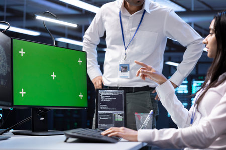 Software developers doing checkup on green screen computer in server room used for artificial intelligence workloads. IT staff members inspecting neural network data center facility with mockup PCの写真素材