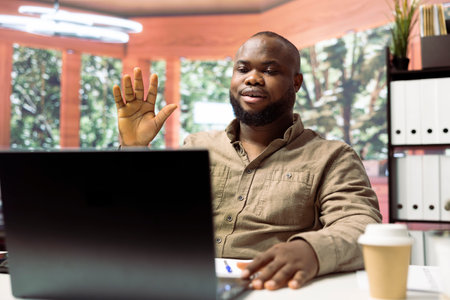 Entrepreneur attends videoconference call from his home office, presenting annual data statistics...