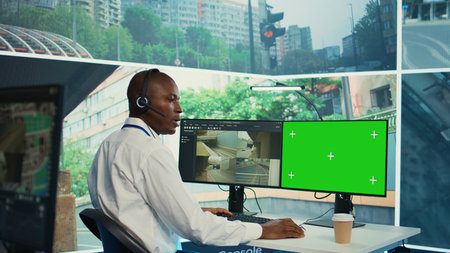 African american agency worker using CCTV footage and isolated display, monitoring traffic through...