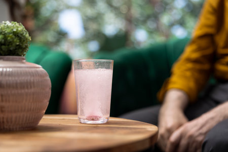 Elderly people drinking effervescent vitamins dissolved in water glasses, using for recovery and hydration. Senior couple taking supplements for wellness and longevity. Close up.の写真素材