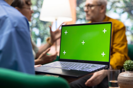 Medical assistant visiting elderly couple for checkup at their home, using isolated display and doing a consultation to give treatment and vitamins for recovery. Nurse talking to senior patients.の写真素材