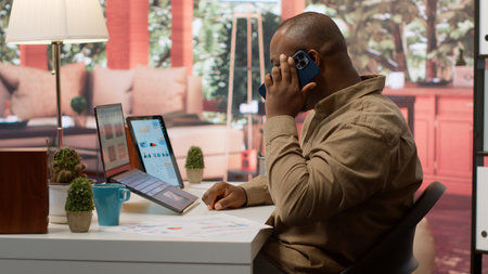 Entrepreneur reviewing statistics data on a laptop remotely from his house, makes a briefing report. Business owner studying sales numbers and the profit to increase organizational funds. Camera A.の写真素材
