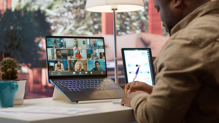 Businessman presents annual sales reports to the shareholders on videocall, working from home to...