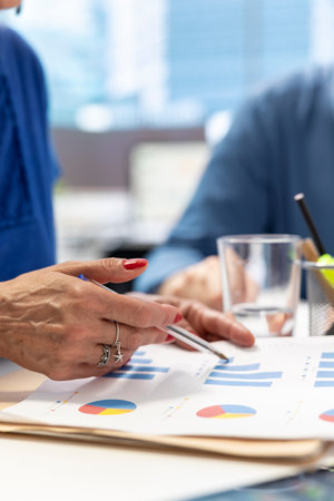 Senior people in a modern office analyzing retirement plans with a financial broker, looking into various pension options. Covering savings and family expenses with future investments.の写真素材