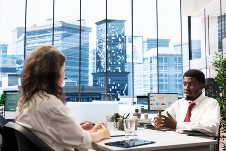 Employee in wheelchair doing business meeting with coworker in office. Person with paraplegia feeling dignified by diversity, inclusion and equal opportunities for people with disabilities at workの写真素材