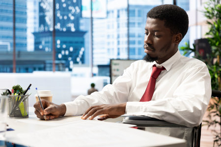 Recruiter hiring person with impairment for newly opened company position after CV matched job description. HR expert employing wheelchair user after being happy with his resumeの写真素材