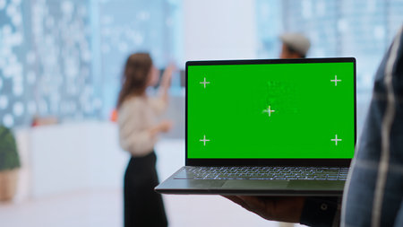 Realtors and client evaluating blueprints next to green screen display, working on new high class office space layout development. Businesswoman sharing her interior design vision. Camera B.の写真素材