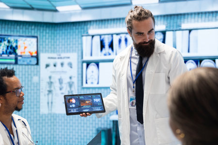 Neurology experts meeting to examine a mri brain scan in cabinet office, discussing potential illness based on tomography test results. Team of specialists analyze hospital records.の写真素材