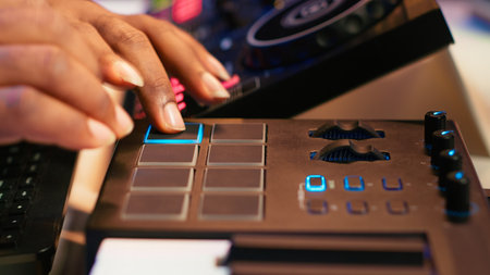Audio engineer producing new music on mixing console in home studio, working with sound effects and...