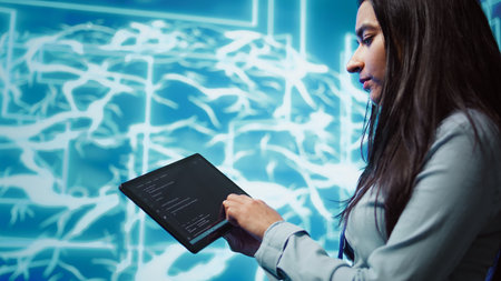 Engineer uses tablet and AI deep neural networks modeled after human brain to solve complex problems. Close up of admin using machine learning model to look at data and better complete tasks, camera Bの写真素材