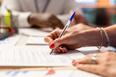 Elderly woman giving her signature on retirement plan contract, choosing the suitable pension option with life insurance policy to secure the future income and family expenses. Close up.の写真素材
