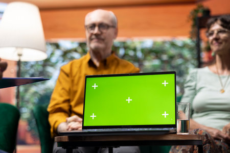 Social caretaker visiting elderly people patients at their home, using isolated mockup and doing a consultation to give treatment and vitamins for wellness. Nurse talking to old couple.の写真素材