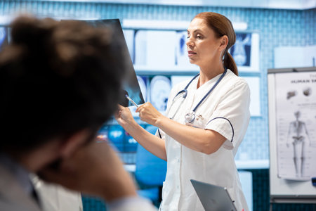 Medical experts meeting in a cabinet to discuss radiography test results, analyze x rays and...