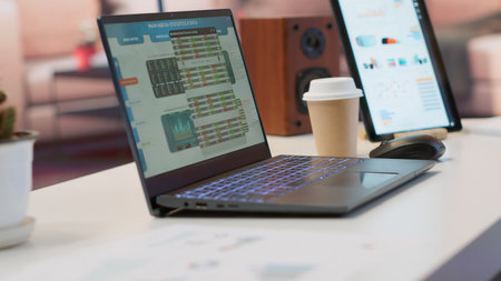 Empty modern office of a business entrepreneur with laptop running financial analysis plans for startup investment and expansion. Remote work on infographics and bank account analytics.の写真素材