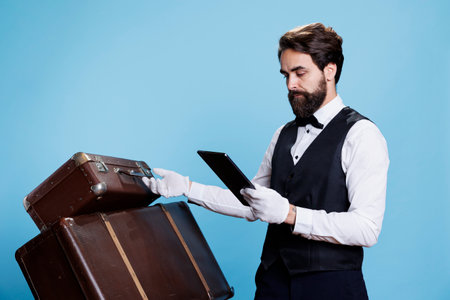 Doorman holds tablet in hand to advertise professionalism of hotel industry, showcases hospitality...