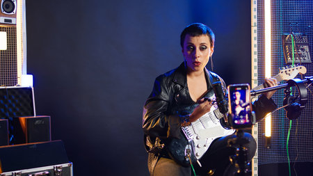 Singing coach recording an online lesson for voice training in studio, vocal exercises on live stream tutorial. Musical instructor with a heavy metal vibe teaching the basics. Camera A.の写真素材