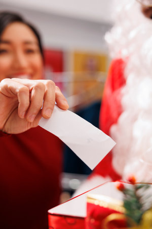 Asian adult drawing name from box to announce raffle giveaway winner during christmas promotions...