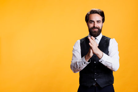 Positive person applauding someone on camera, clapping hands to express congratulations for success. Happy person with suit and tie cheering for person in studio, boost confidence in friendly way.の写真素材