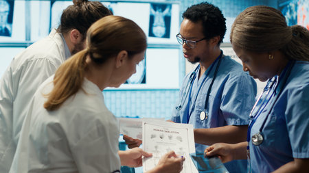 Hospital staff reviews human anatomy to give the correct diagnostic in a cabinet meeting. Group of medics ensure accurate treatment service for disease prevention, radiology department. Camera A.の写真素材