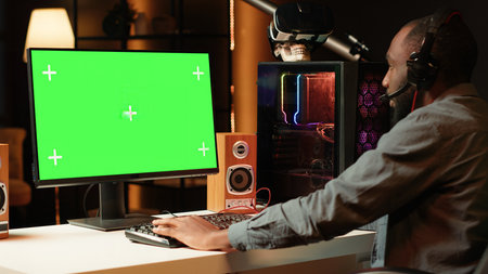 Gamer using keyboard and mouse to play videogame on gaming PC isolated screen monitor. Man in...