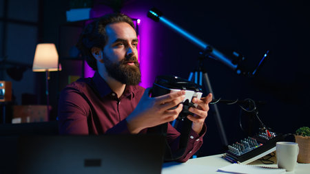 Close up shot of futuristic VR goggles held by man reviewing them for viewers. Internet star filming technology channel vlog for gadget enthusiasts, showcasing virtual reality headset, camera Bの写真素材