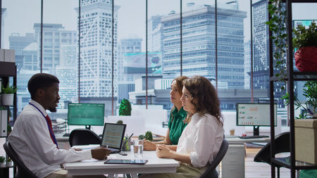 HR expert interviewing two job applicant to fill a vacancy within the organization, talent acquisition. Male recruiter discussing with talented businesswomen with impressive CVs. Camera B.の写真素材