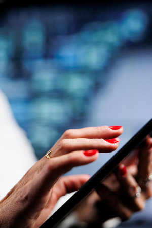 Computer scientist using tablet to make sure valuable data remains shielded from security hassles, safeguarding high tech workspace servers against unauthorized access and vulnerabilities, close upの写真素材