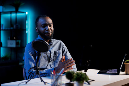 Entertainer using professional mic to record himself chatting with internet audience. Content...