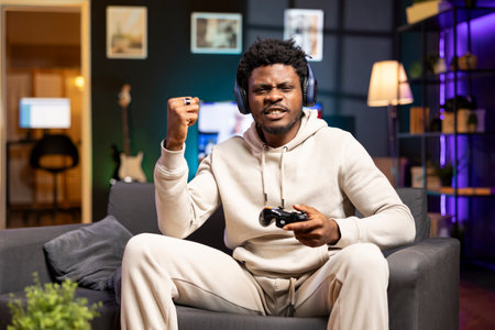 Cheerful gamer feeling excited after finally defeating all enemies and winning, celebrating,...