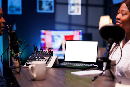 Detailed view of laptop featuring blank chromakey screen for talk show promotion. Selective focus on...
