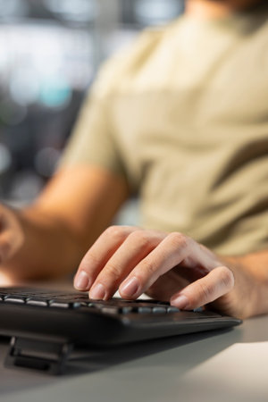Accountant typing on keyboard, imputing revenue figures on computer in office. Close up of man at desk focused on typing company statistical numbers, working hard to finish job before deadlineの写真素材