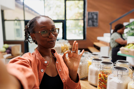 Black woman wearing spectacles doing a video advertisement of local eco friendly shop. African...