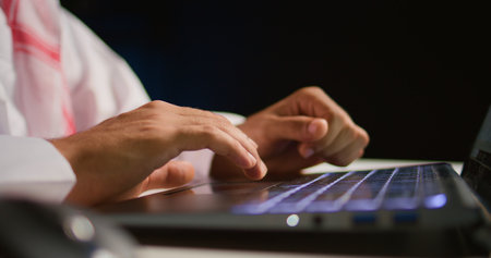 Close up shot of businessman using laptop in office to send emails. Worker typing on notebook...