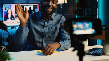 African american content creator films video review of book, presenting synopsis to audience and giving feedback. Internet star sponsored by publisher to show new novel release to subscribersの写真素材