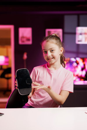 Gen Z media star filming video about best virtual reality headset launched this year. Kid tech content creator recording VR goggles device review, assessing build quality and performanceの写真素材