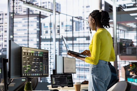 Engineer using laptop device, working with machine learning tech advancing AI critical to innovation...