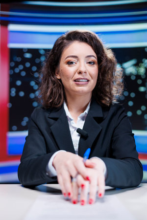 Woman broadcaster transmitting live breaking news in media studio, discussing about latest happenings and interesting events. Journalist reading headlines and giving insight to viewers.の写真素材
