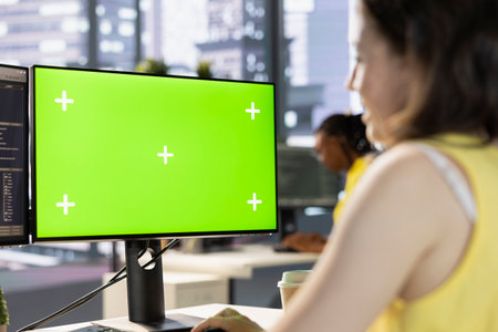 Worker conducting code review on green screen computer to fix bugs, identifying performance and...
