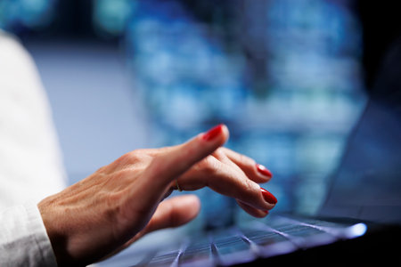 Person using laptop, setting up high bandwidth dedicated multiplayer gaming servers in high tech workspace to accommodate more traffic from worldwide locations and avoid low ping, close upの写真素材