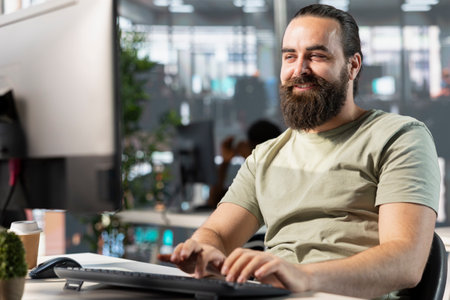 Happy worker looking at PC monitor, satisfied after finding business insights to finish project...