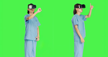 Operating with advanced interactive 3d headset, nursing staff uses virtual reality goggles against greenscreen backdrop. Artificial intelligence utilized by medical healthcare professionals.の写真素材